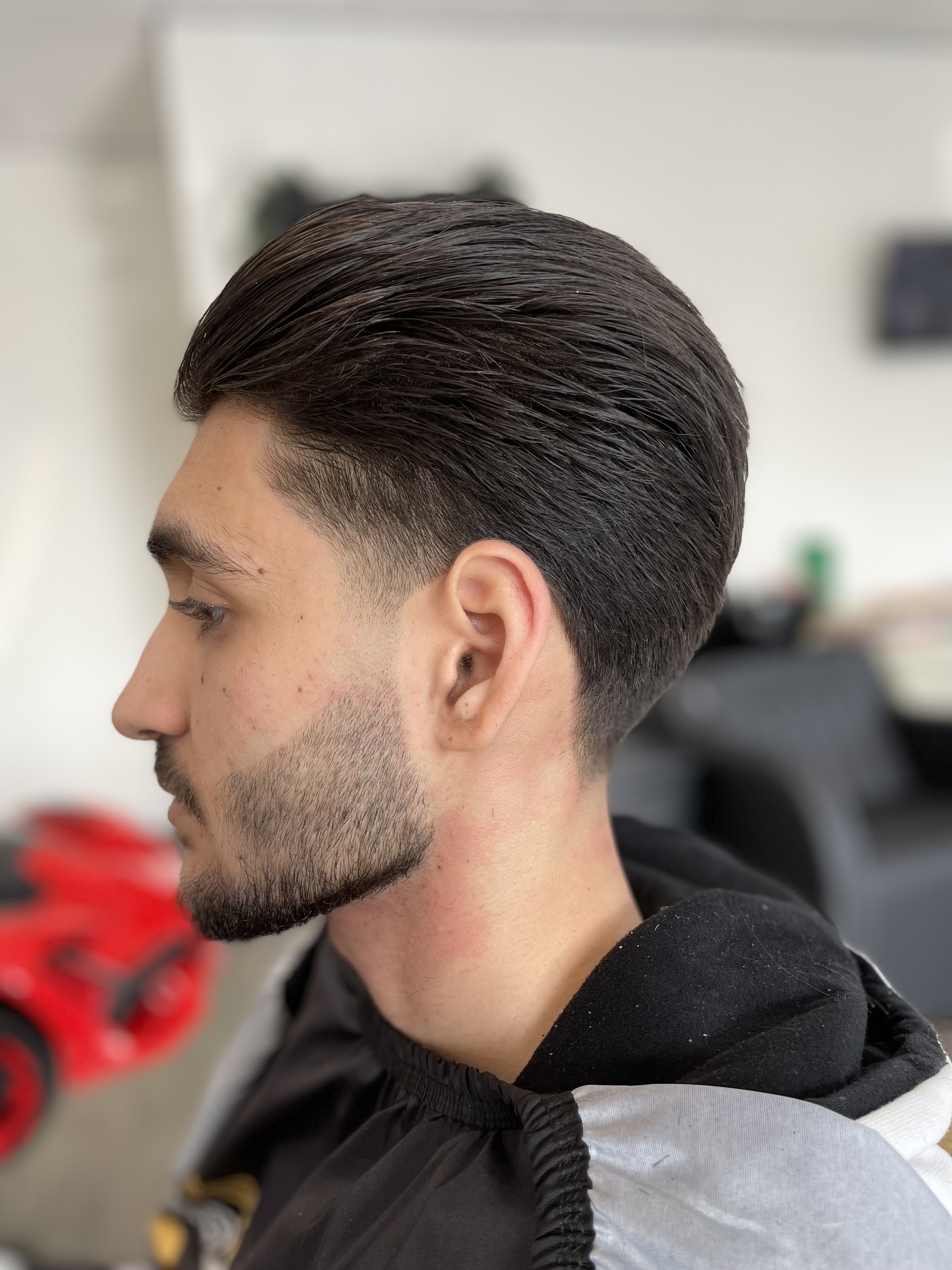 Strak achterovergekamd haar met verzorgde baard