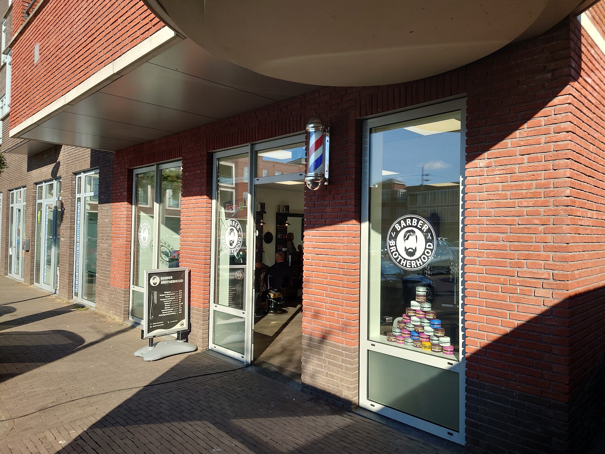 De ingang van Barber Brotherhood aan het Kloosterplein met barberpaal